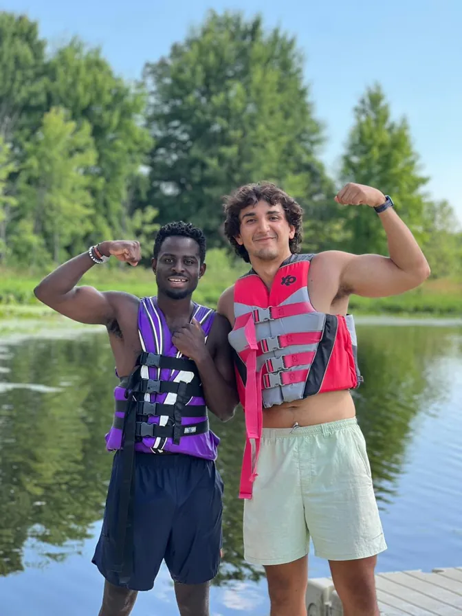 Dos counselors con chalecos salvavidas junto al lago