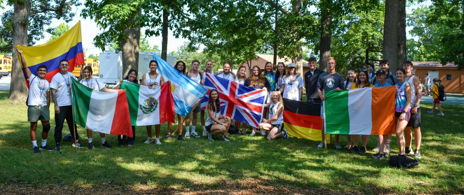 Counselors de varios países, entre ellos Colombia, posando con sus banderas en el campamento