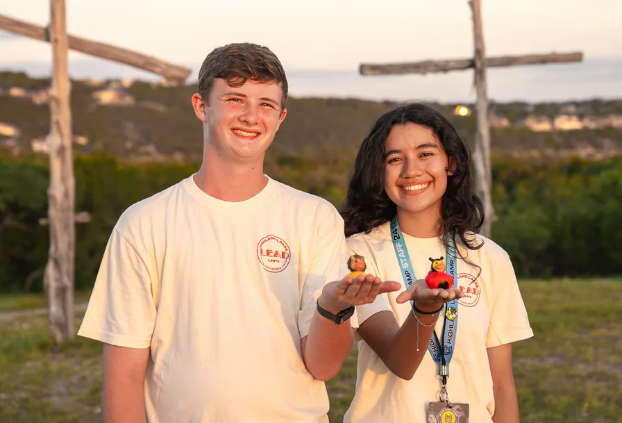 Dos counselors sonriendo al atardecer en el campamento