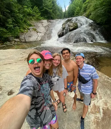 Grupo de amigos tomándose una selfie frente a una cascada