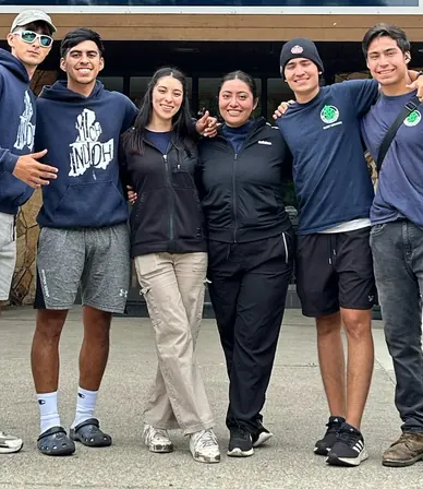 Seis travelers abrazados frente al campamento